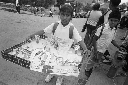 In Valle de Allende, Mexico, a school child carries her homework assignment, an altar for Día de los Angelitos, the first of three days when participants honor and commune with deceased ancestors. 