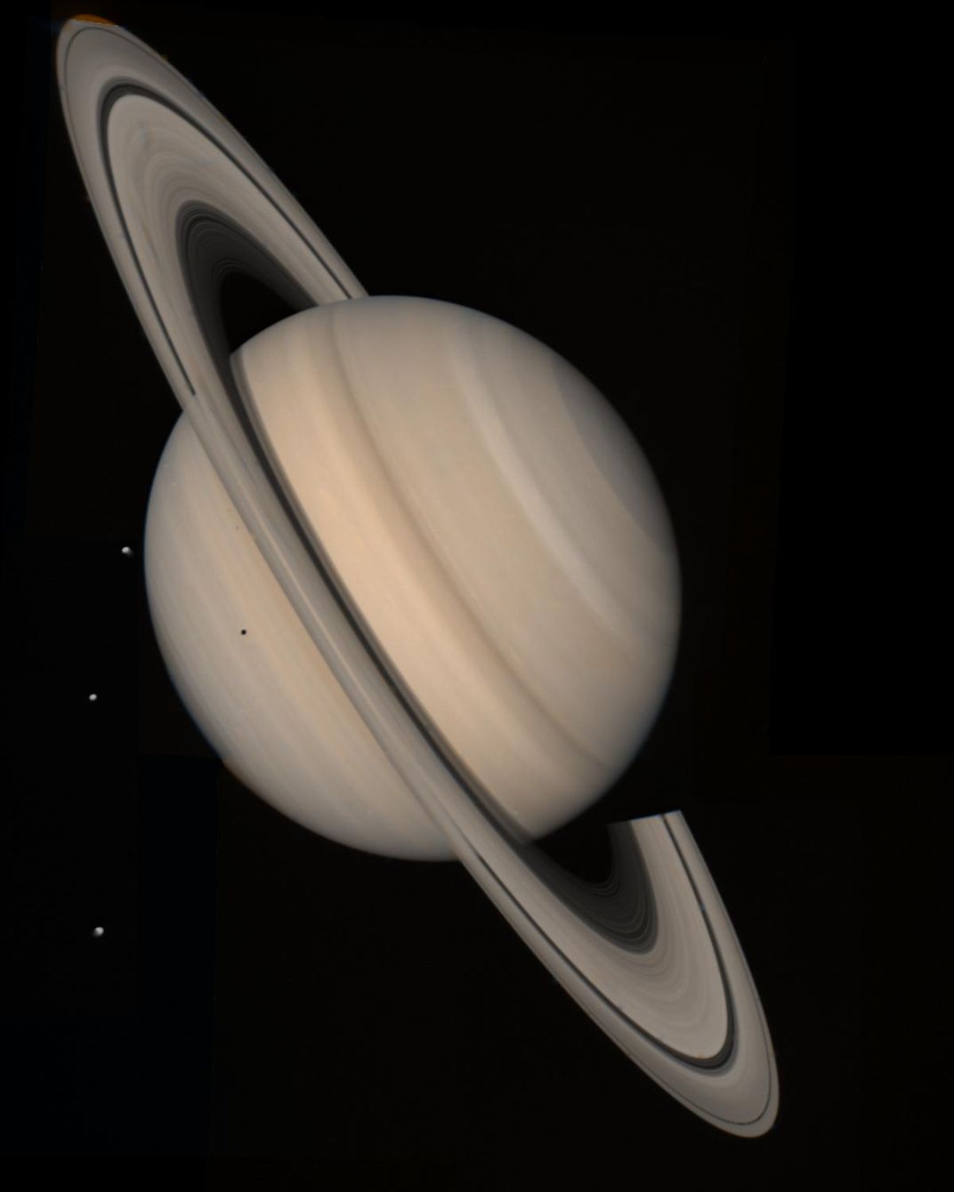 saturn, at a steep tilt, with its rings and several moons visible