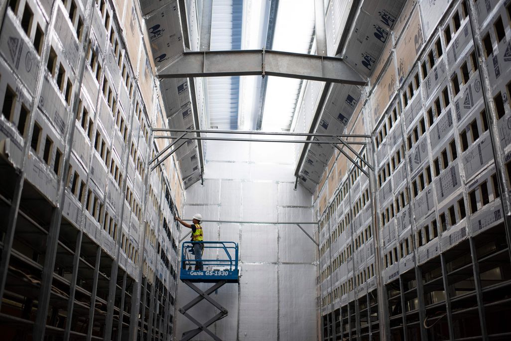 A worker on a lift in a bitcoin mining facility