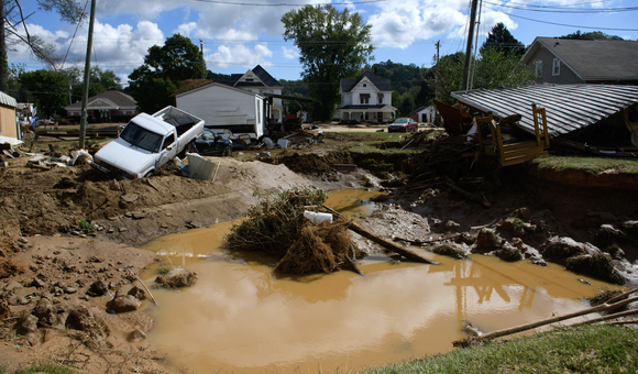Debris is heaped on the banks of a river.