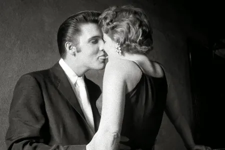 The Kiss
In the privacy of the narrow hallway under the fire stairs of the Mosque Theater, while other performers are on stage before 3,000 fans in the audience, Elvis is concentrating on his date for the day.