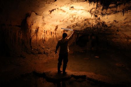 One of the archaeologists examines a partially flooded chamber of the cave that holds many of the drawings.