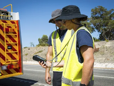 Members of Western Australia&#39;s Department of Fire and Emergency Services search an 870-mile stretch of highway for a radioactive capsule believed to have fallen off a truck.