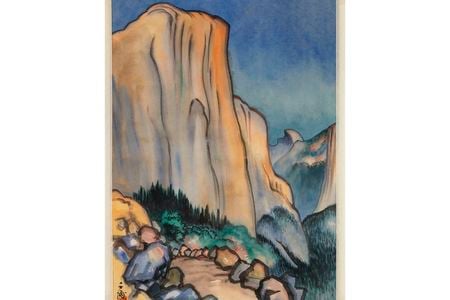 Watercolor image of mountain scene with a cloudless blue sky, trees and boulders in the foreground, and the artist’s stamp in the bottom left-hand corner.