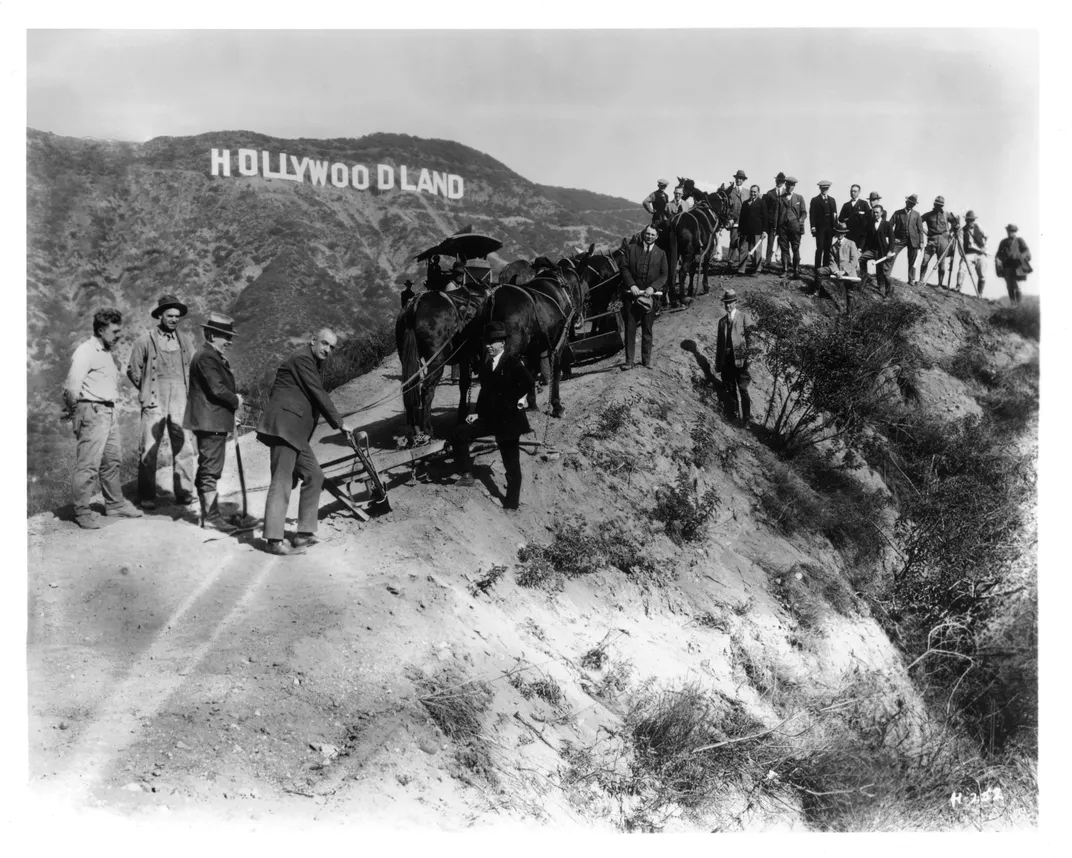 A 1920s photo of workers posing in front of the Hollywoodland sign