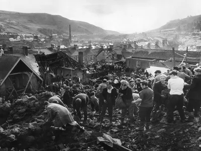 Helpers fill sandbags on the tip above the shattered Pantglas Junior School to divert a spring and avert the risk of further landslides at Aberfan, South Wales.