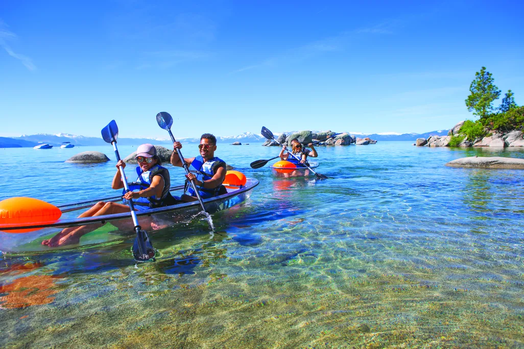 People kayaking on clear lake waters