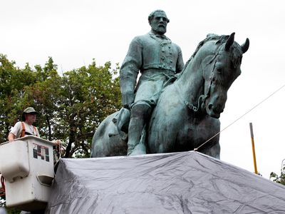 In Charlottesville, Virginia, city workers drape a tarp over the statue of Confederate General Robert E. Lee in Emancipation park to symbolize the city's mourning for Heather Heyer, killed while protesting a white nationalist rally in August. 
