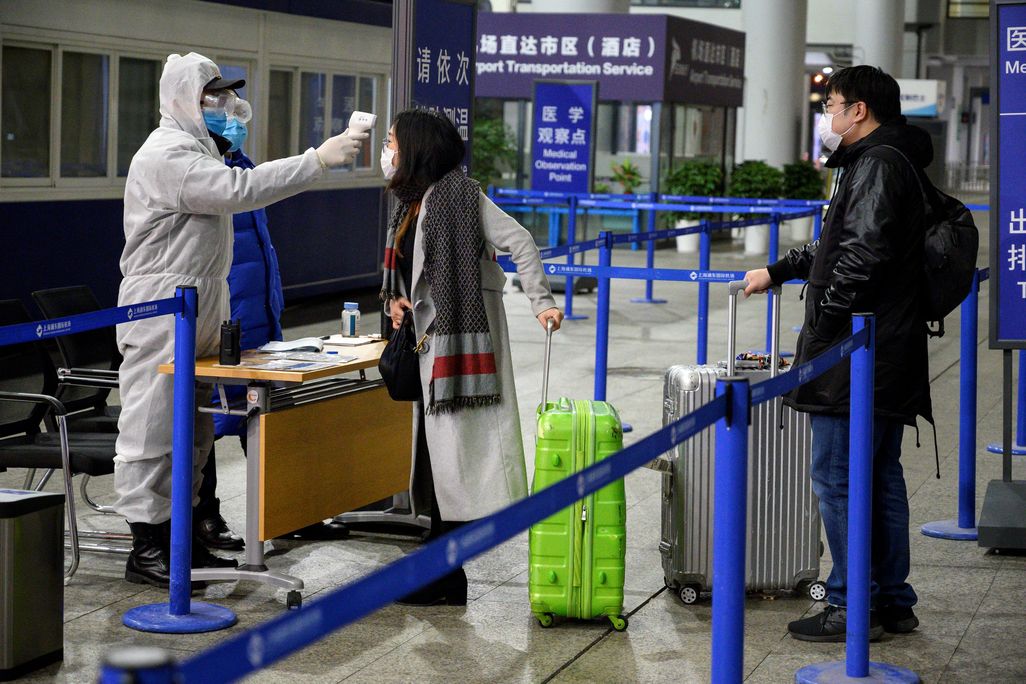Travelers at Shanghai Pudong International Airport in Shanghai getting their temperatures taken