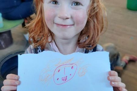 Five-year-old Astrid Cooper poses with one of her artworks. Astrid co-curated an upcoming exhibition at the Edge arts center in Bath, England, with her father, Will.