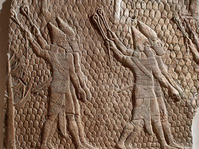 A stone relief carving of soldiers made in Assyria and now in the British Museum.