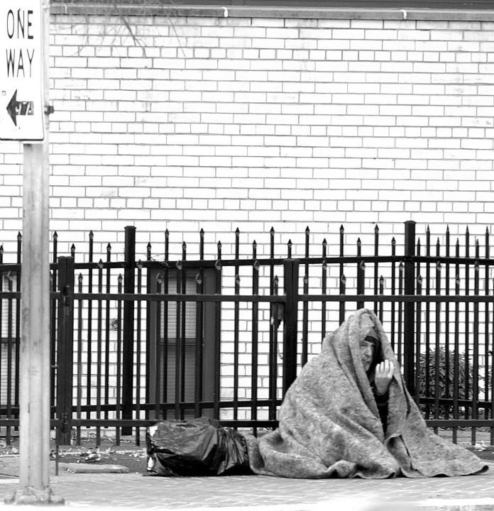 A homeless man sits on a street corner in Washington DC. Smithsonian