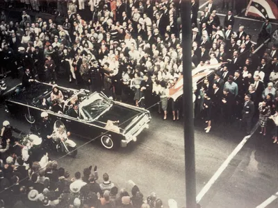 President John F Kennedy, First Lady Jacqueline Kennedy, and Texas Governor John Connally ride through the streets of Dallas, Texas prior to the assassination on November 22, 1963.