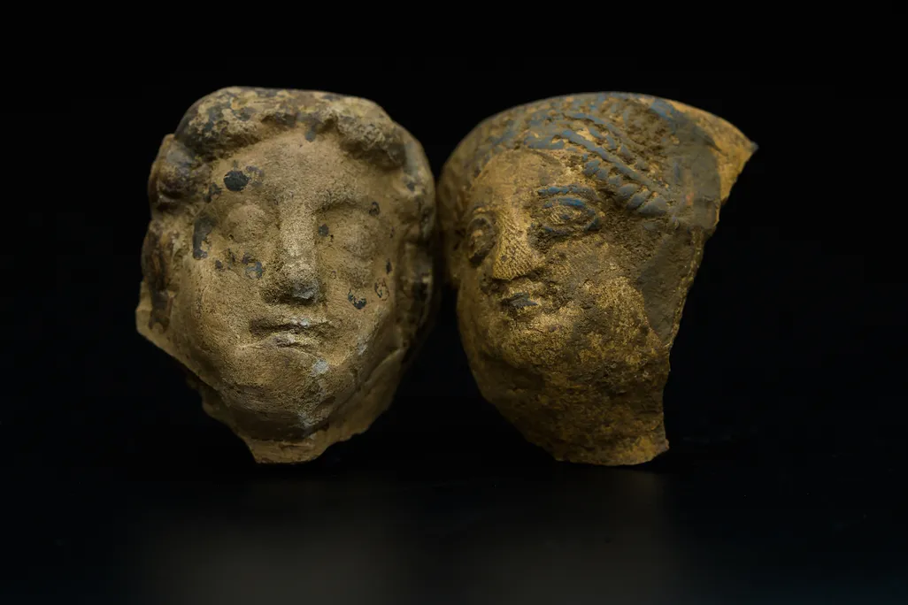 two stone fragments of faces