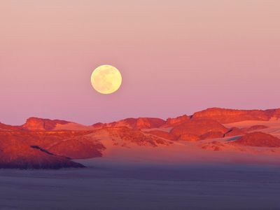 The moon rises over the Sahara Desert. New research links a rising moon to lower humidity and a decreased chance of rain. 