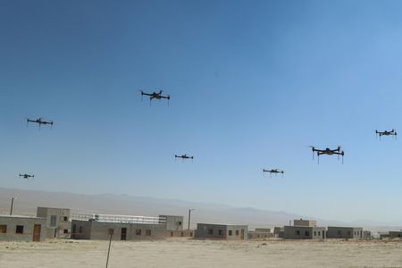 This is only a drill, for now: Over the fictional town of Razish at the National Training Center at Fort Irwin, California, 40 quadcopters fly in a swarm.