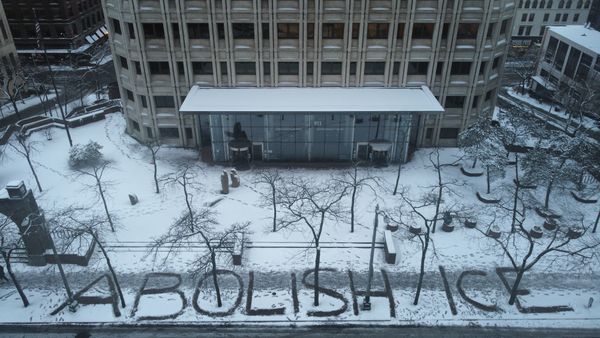 "ABOLISH ICE" spelled out in the snow in front of ICE headquarters in Seattle thumbnail