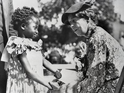 Eleanor Roosevelt talks to a child at the ceremonies inaugurating the slum clearance in Detroit, Michigan.