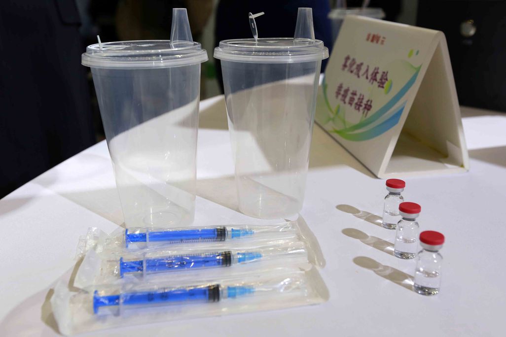 Vials, cups and syringes for a Covid-19 vaccine on a table.