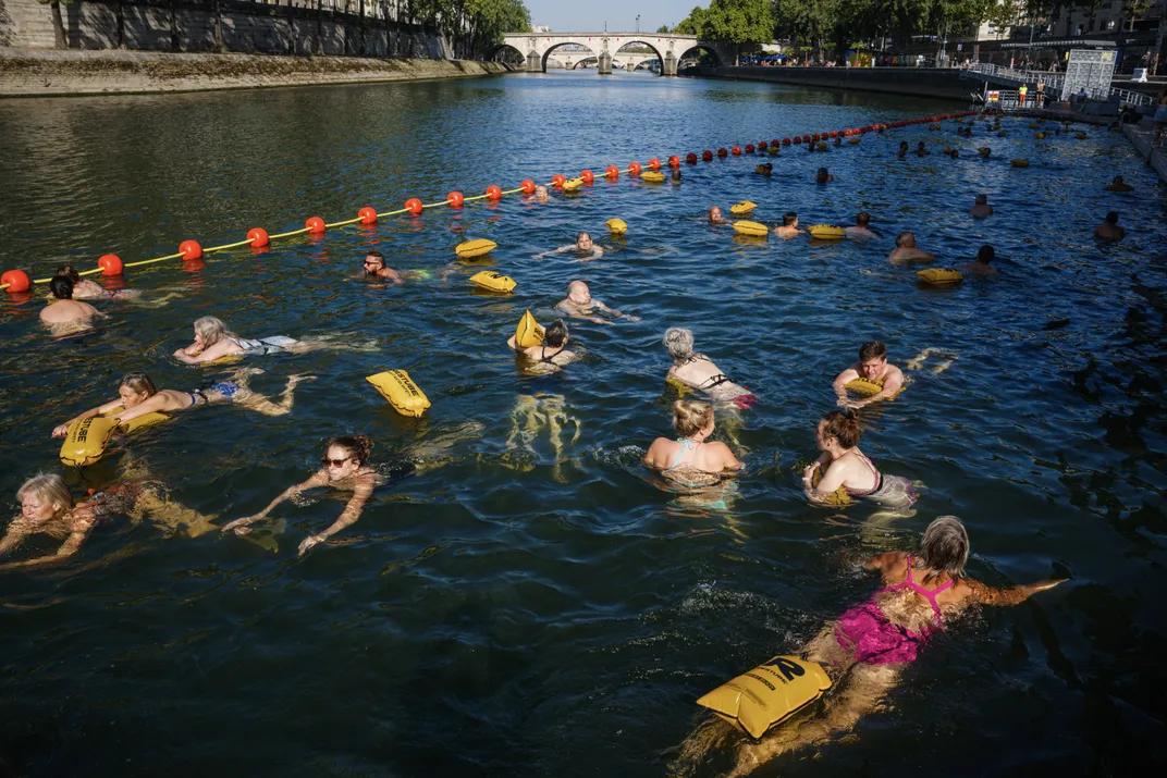 swimmers in the Seine float around in a designated swimming area