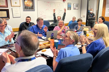 Members of the Voyager 1 flight team celebrate after receiving health and status data from the spacecraft. Next, engineers need to enable the probe to start sending science data again.