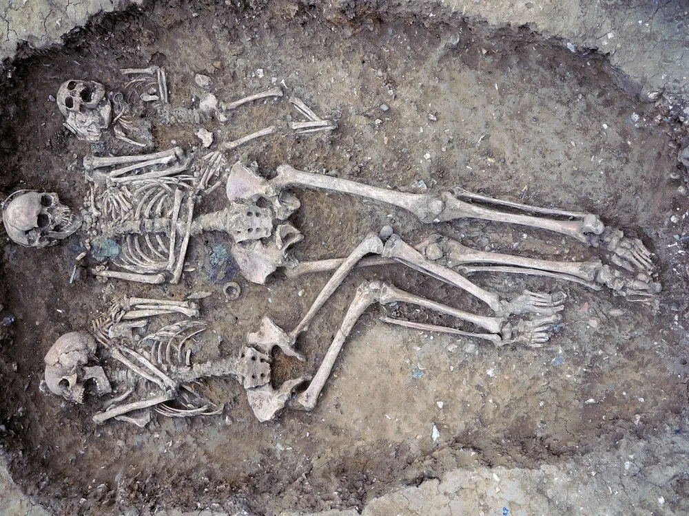 an ancient grave with two adult and one child skeleton