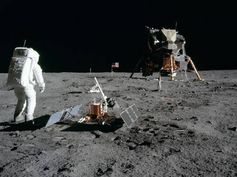 An astronaut on the surface of the moon with some equipment