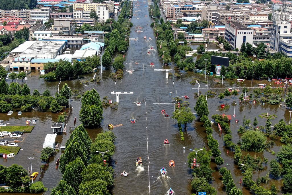 Aerial photo of a flooded intersection with cars, trees and boats after heavy rainfall