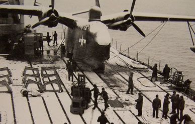 Pine Island, anchored off Antarctica during Operation Highjump, prepare a PBM-5 Mariner for flight during a snowstorm.