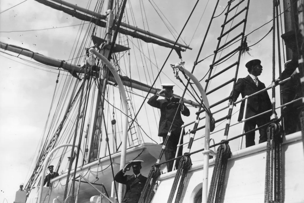 Shackleton and his second in command salute from a ship
