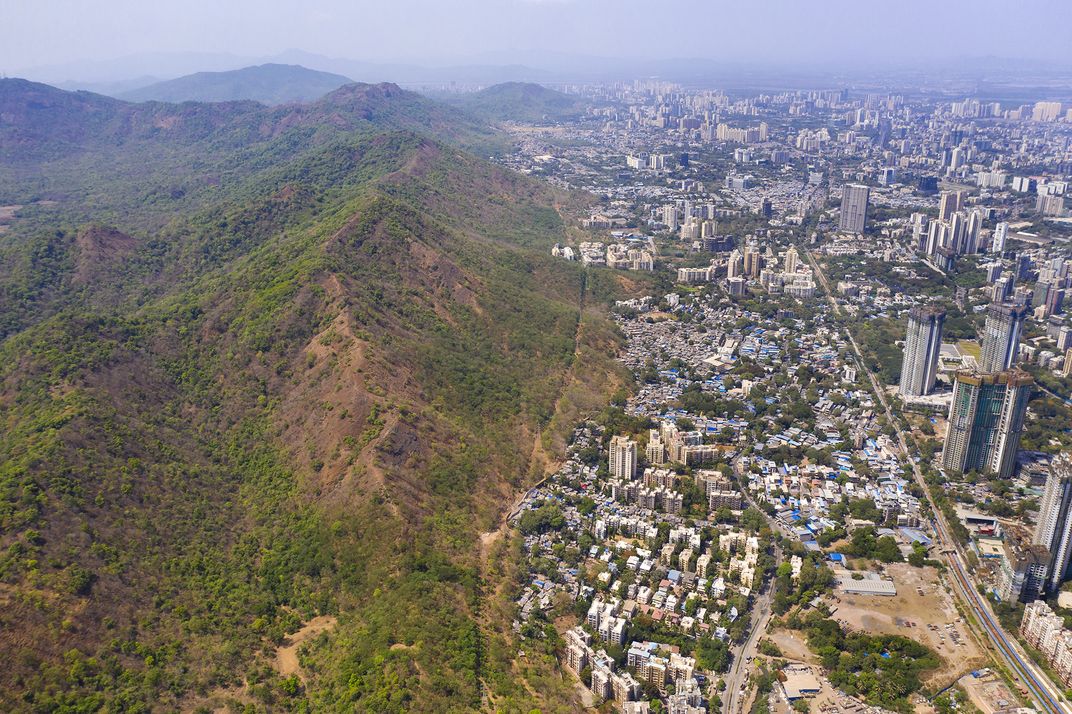 An image of a city contrasting with a mountainous landscape.