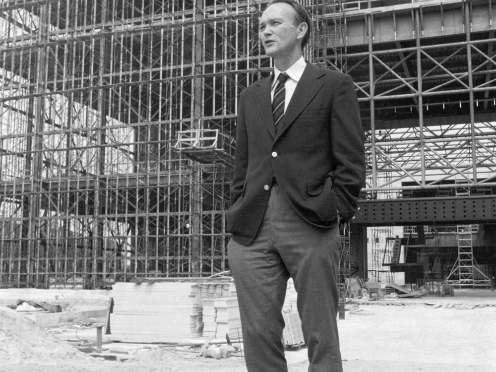 Michael Collins, the Museum's third director, stands before the steel skeleton of the new National Air and Space Museum in July 1974.
