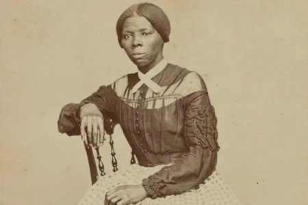 A crop of a carte-de-visite of Harriet Tubman seated in an interior room.