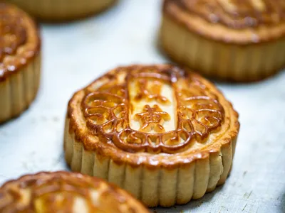 The miniature cakes, which fit in the palm of a hand, are most commonly made with a thin pastry layer encasing a dense filling of sweetened red beans, melon pur&eacute;e or mixed nuts.