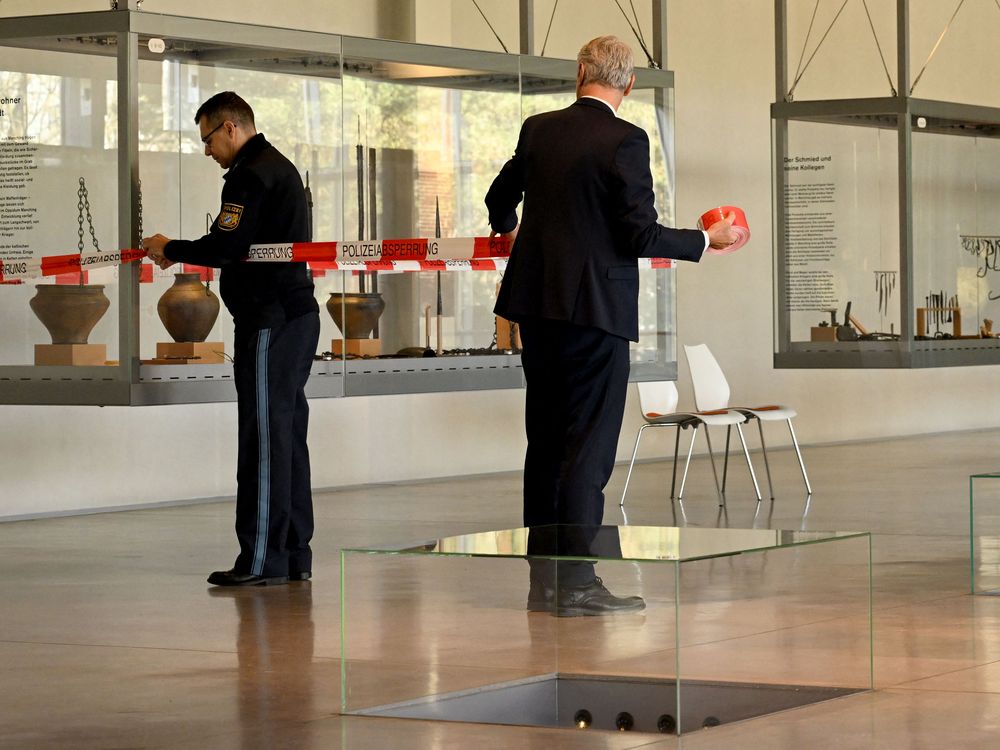 Policemen fix a barrier tape on November 23, 2022 in the exhibition room of the Celtic and Roman museum in Manching, southern Germany, where a hoard of Celtic coins was on display before the treasure was stolen.