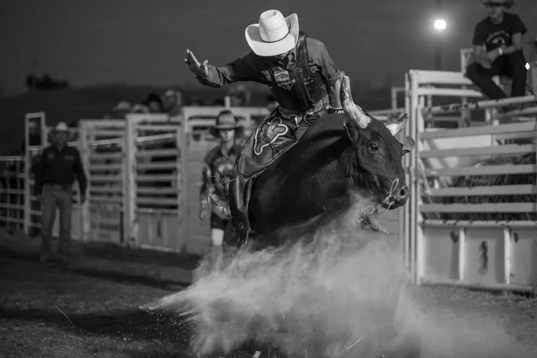 13 - A man rides a bull at the Oglala Lakota Nation Fair and Rodeo, a cultural and sporting event held annually in Pine Ridge, South Dakota.