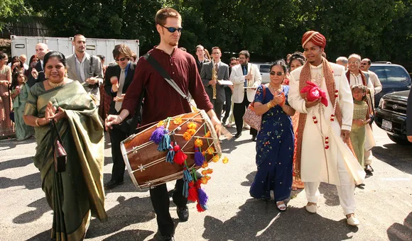 After composing and transcribing music for my wedding day, Red Baraat was born. Dave Sharma leads the baraat (wedding procession) on dhol, as I walk with my mother, family, and friends. August 27, 2005. (Photo courtesy of Sunny Jain)