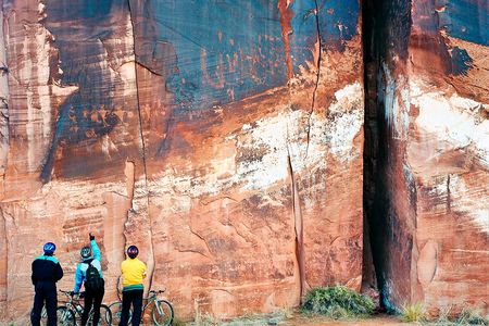 Cyclists Inspecting Ancient Petroglyphs, Utah, 1998: Texas-based photographer Terry Falke captures several of the exhibition's themes in this image of cyclists examining petroglyphs and bullet holes in a stratified rock face by the side of the road in Utah. "You’ve got the ultimate strata, which is man-made, so the idea is that we are impacting, we’re leaving our mark on the Earth over time as well," says Talasek. 