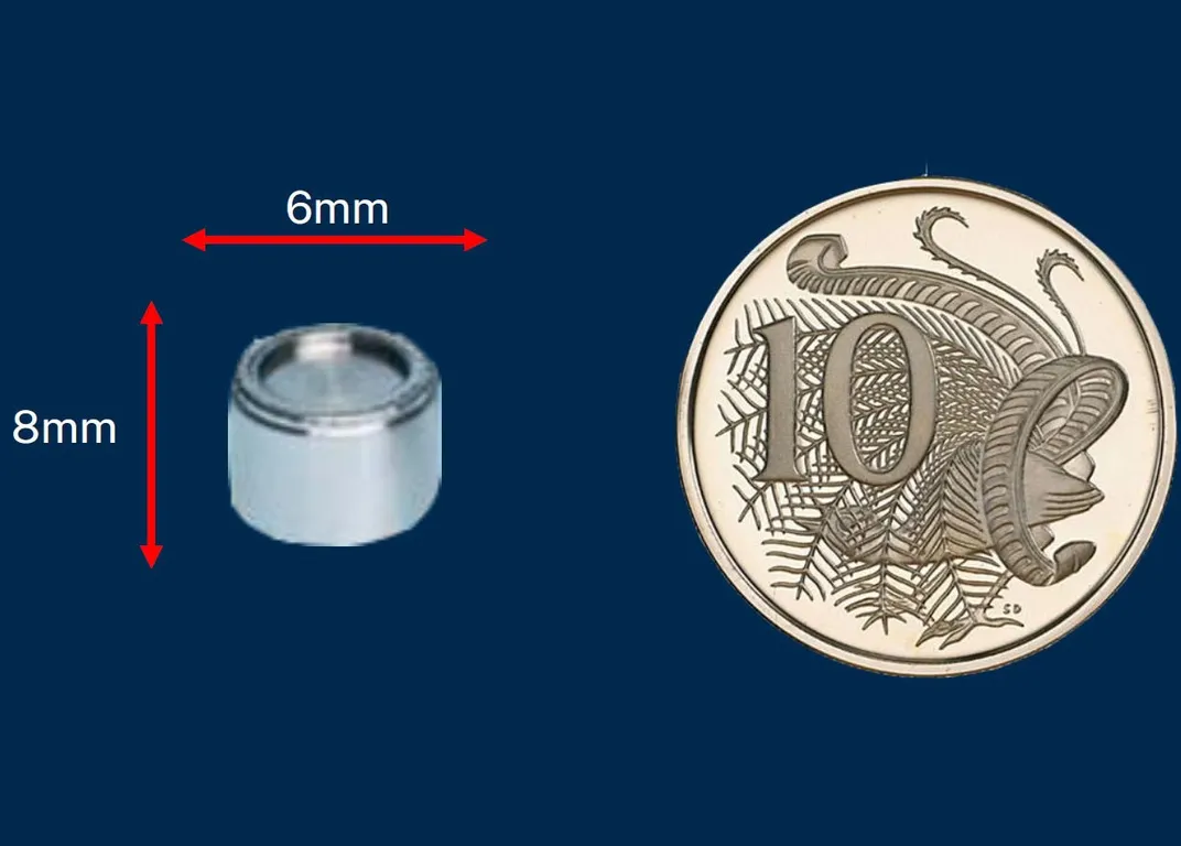 The small silver capsule shown next to a coin for scale