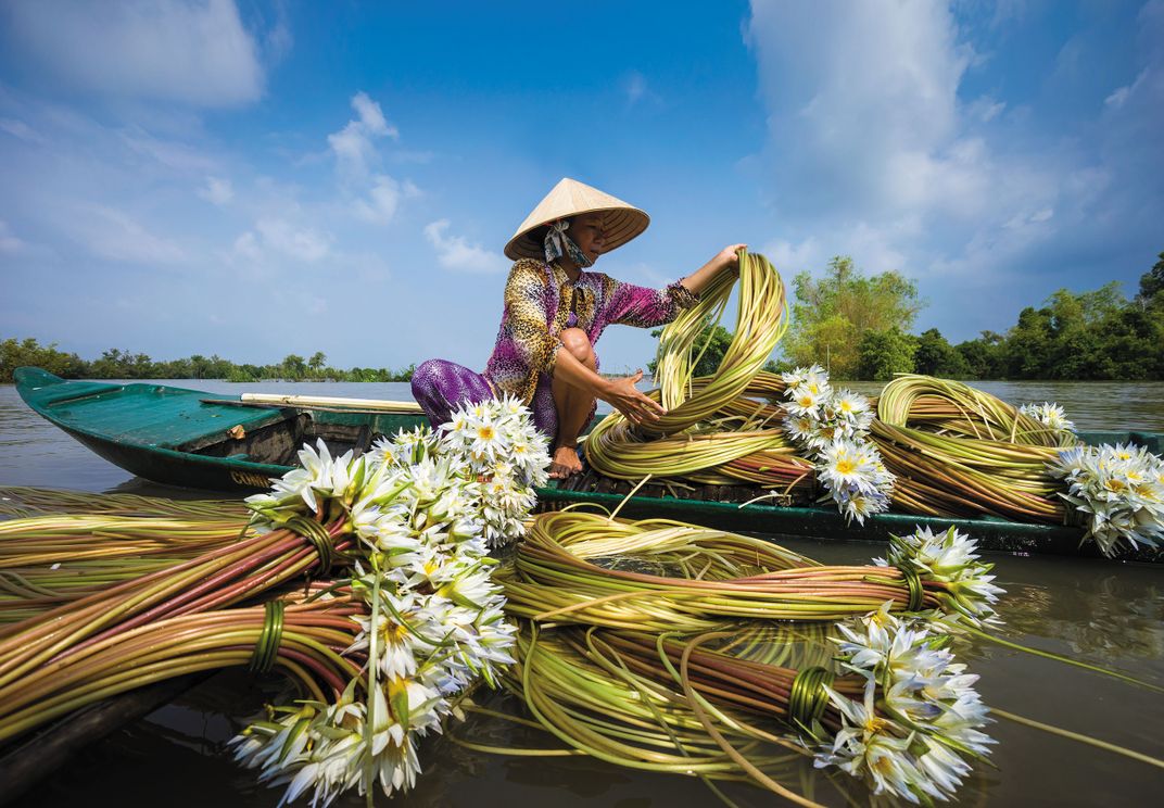 Woman working with flowers on the Mekong. Credit: Nhiem Hoang