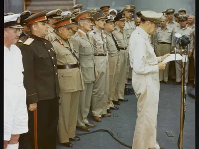 General Douglas MacArthur making remarks at the surrender ceremony aboard the USS Missouri. Behind him are representatives of the major Allied powers. U.S. National Archives, Army Signal Corps Collection, USA C-2716.