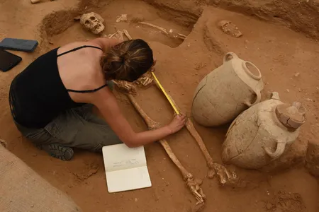Rachel Kalisher, a member of the physical anthropology team, measures a 10th-9th century BC skeleton