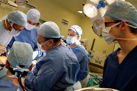 Adrian Sugar (seated second from left) and his surgical team during the facial rebuild operation at Morriston Hospital. The team reconstructed 29-year-old Stephen Power's face using models and implants from a 3D printer.
 