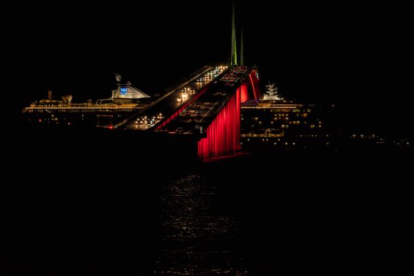 Illuminated Skyway Bridge busy with holiday traffic appears to bisect the cruise ship thumbnail