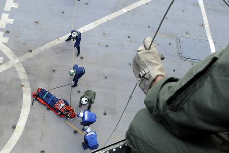 090920-N-7478G-286
PACIFIC OCEAN (Sept. 20, 2009) A naval air crewman, assigned to the Warlords of Light Helicopter Antisubmarine Squadron (HSL) 51, holds a rescue line as hospital corpsman from amphibious command ship USS Blue Ridge (LCC 19) train for medical evacuations underway. (U.S. Navy photo by Mass Communication Specialist 2nd Class Cynthia Griggs/Released)