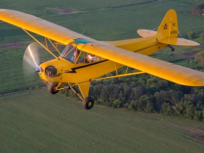 Jessica Voruda and a passenger fly in a Piper J3C Cub over farmland near Hartford, Wisconsin in July, 2017.
