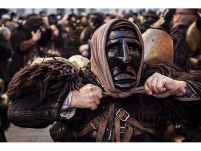 Loaded with leather and sheepskins, Salvatore Gungui tightens his headscarf. Although only men dress as Mamuthones, the scarf adds a feminine element.