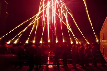 U.S. Sailors ring in the new year aboard the aircraft carrier USS Carl Vinson (CVN 70) with a qualification fire of pencil flares while under way in the Pacific Ocean in the first time zone west of the International Date Line Jan. 1, 2010.  Carl Vinson and Carrier Air Wing (CVW) 17 are on a deployment to the U.S. 7th Fleet area of responsibility. (DoD photo by Mass Communication Specialist 2nd Class James R. Evans, U.S. Navy/Released)
