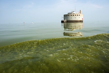 The Lady K tow boat kicks up a wake full of green algae a few hundred feet from the city of Toledo's Water Intake on Lake Erie, for testing on Monday, August 4, 2014.