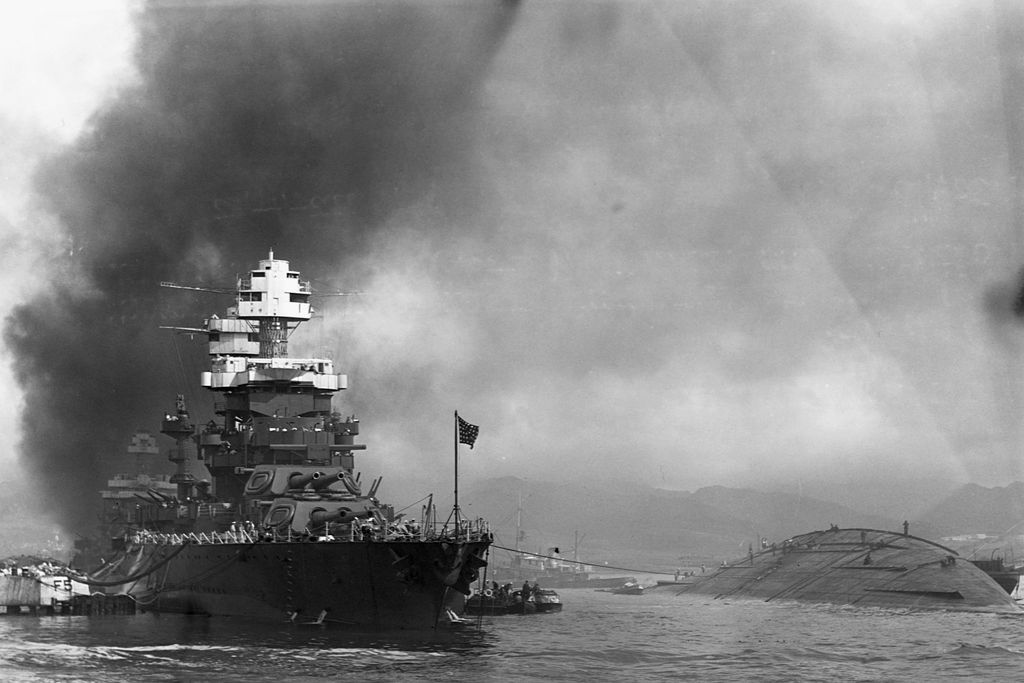 The capsized USS Oklahoma and the USS Maryland